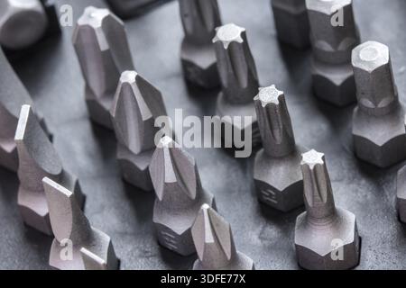 Set of bits for the screws. Selection of different shapes and bits for a screwdriver. Macro view of tools Stock Photo
