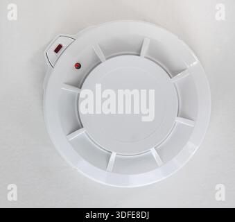 Smoke detector on the ceiling. Smoke sensor mounted on roof in apartment Stock Photo