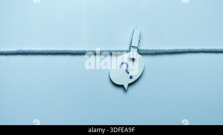 Question Mark Speech Bubble Hanging on String with Clothespin for FAQ and Support Concepts Stock Photo