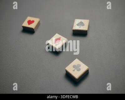 High Angle View of Wooden Tiles with Playing Card Suits Scattered Across Dark Background Stock Photo