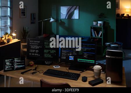 Empty Home Office Workspace Featuring Multiple Monitors Displaying Programming Code Stock Photo