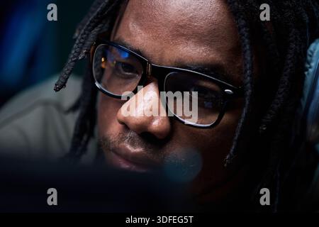 Young Black Man Wearing Glasses Concentrating While Using Computer Stock Photo