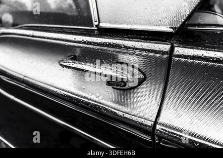 Door handle of a retro car in raindrops, close-up. Black and white Stock Photo
