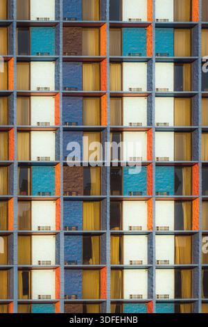 View of vibrant, geometric patterns of blue, orange, brown, and white rectangles repeating across the building's facade, creating a modern mosaic, Las Stock Photo