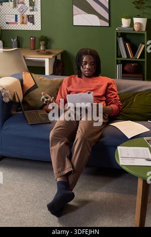 Young Indian Woman Studying Documents While Sitting on Sofa at Home Stock Photo