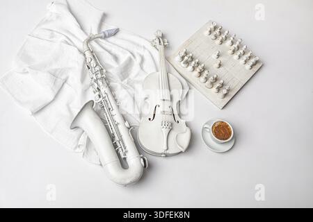 Saxophone, violin, chess and cup of coffee on a white background Stock Photo