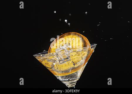 Glass with orange and ice with water splashes Stock Photo