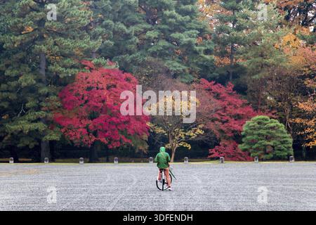 Man on bicycle standing in autumn park with trees with colored leaves Stock Photo