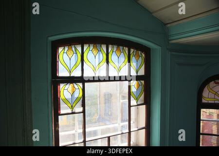 Fragment of a window with a stained-glass window on a staircase of an apartment house on Kolokolnaya street in St. Petersburg Stock Photo