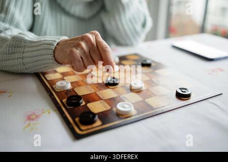 Senior Woman Playing Checkers, close-up Stock Photo
