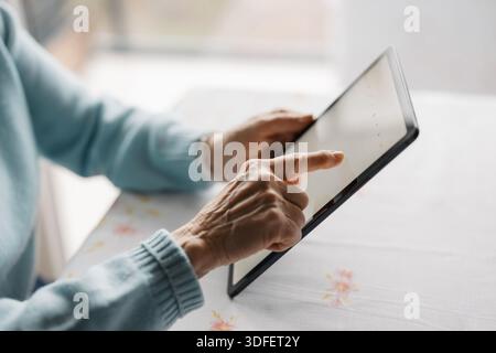 Senior woman using digital tablet at home Stock Photo