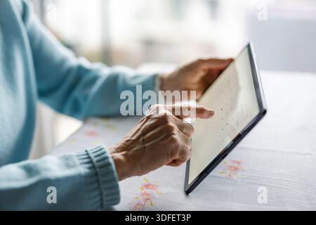 Senior woman using digital tablet at home Stock Photo