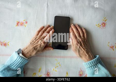Senior woman using smart phone at home Stock Photo
