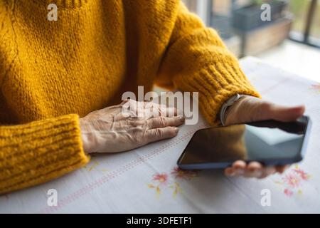 Senior woman using smart phone at home Stock Photo