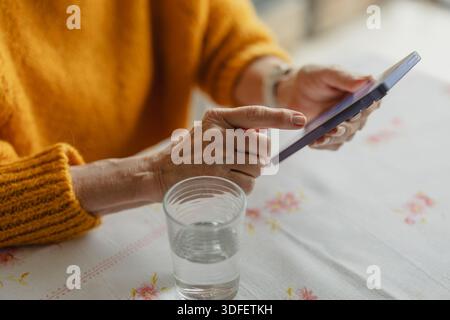 Senior woman using smart phone at home Stock Photo