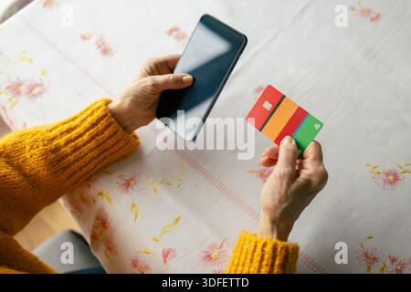 Senior woman shopping online with smartphone and credit card on hand Stock Photo