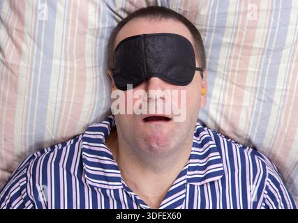Man sleeping with a mask on eyes Stock Photo