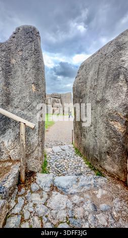 Aerial view of the ancient stone passageway framed by massive boulders leads to Sacsayhuamán under a brooding sky, Cusco, Peru. Stock Photo