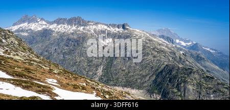 Panoramic view of snow-capped mountains under a clear blue sky. Stock Photo