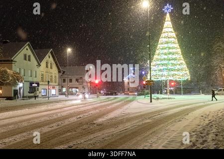 Domzale city during heavy snowfall with beautiful christmas decorations, christmas lights on trees, in the park, christmas trees, snow on roads Stock Photo