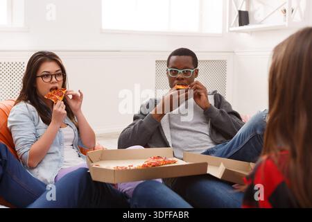 Students sharing pizza at home party Stock Photo