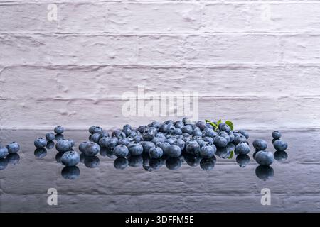 The controlled chaos of a frozen shower of blueberries, captured in mid-air against a black background, like an ephemeral constellation of fruit Stock Photo