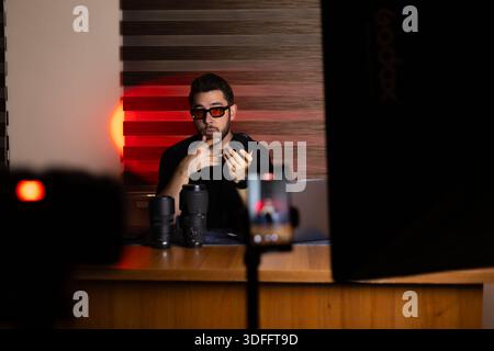 Male blogger recording video content in dark studio Stock Photo