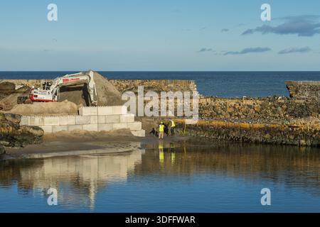 Workers are using JCB diggers to repair the damage caused by waves at Portsoy Harbour. The team is focused on restoring the area and ensuring safety for the community. Credit: JASPERIMAGE/Ģ����ý Live News Stock Photo