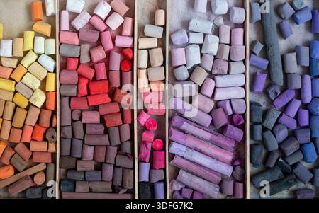 Colored soft pastels crayon set in wooden case. Painter's multicolor background. Chalk pieces top view Stock Photo