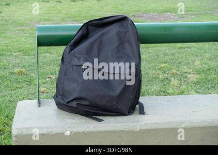 Black backpack. Isolated on a bench. Stock Photo