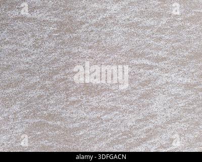 straight white criss-cross lines on flat brown sand surface Stock Photo