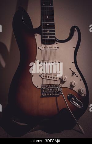 Electric guitar body in the Stratocaster style, showing the instrument’s shape, finish, and hardware details, captured in a close-up view. Stock Photo