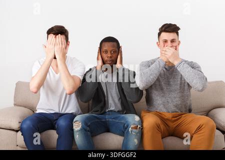 Three wise monkey scene showed by young men in casual Stock Photo