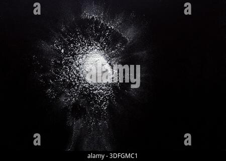 Sprinkled wheat flour splash spots on black background Stock Photo