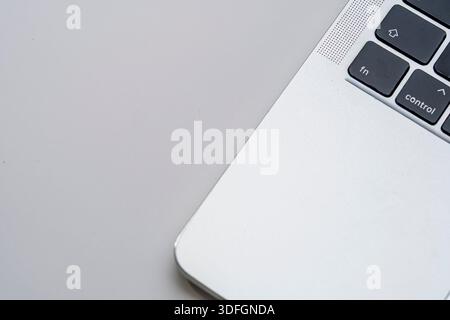 Clean close-up of a laptop keyboard and aluminum body on a light background with generous copy space. Minimal tech concept for productivity and work. Stock Photo