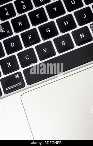 Macro close-up of a laptop keyboard and trackpad. Technology, typing and productivity concept for remote work and modern office life. Stock Photo