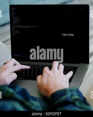 Middle Aged Coder Man Vibe Coding in Artificial Intelligence Infused Integrated Development Environment - Software Engineer Uses AI Based IDE Concept Stock Photo