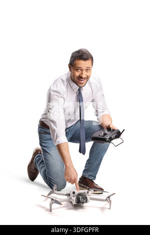 Man kneeling and preparing to fly a drone isolated on white background Stock Photo