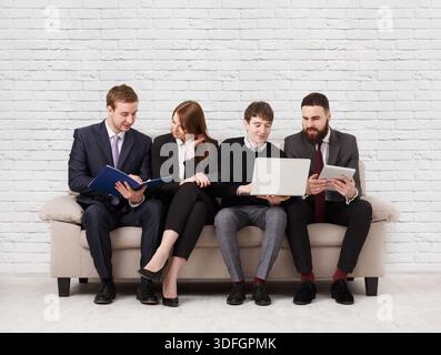 Business people teambuilding. Team on couch, partners working together Stock Photo