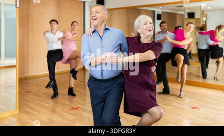 Elderly amateur couple practicing vigorous lindy hop in studio Stock Photo