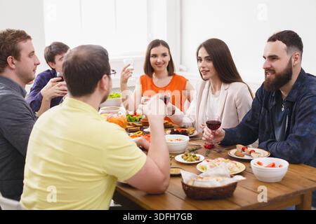 Group of happy young people at dinner table, friends party Stock Photo