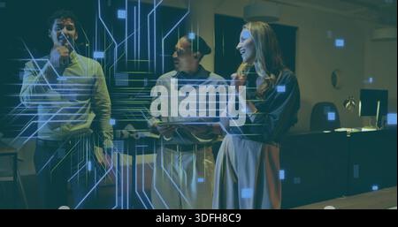 Showing three team members in business attire demoing tech in dim office with tablet and projection Stock Photo
