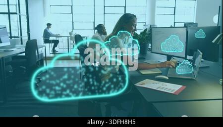 Typing mid-career woman in blouse using laptop with dual monitors at office, neon cloud graphics Stock Photo