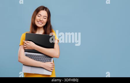 Emotional young woman enjoying her new modern laptop Stock Photo