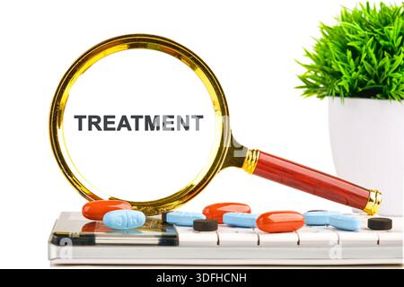 Magnifying glass shows the word Treatment. Pills of varied colors are next to the keyboard and magnifying glass. A green plant is in a white pot on a Stock Photo