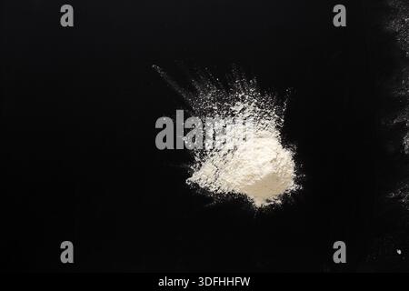 Sprinkled wheat flour splash spots on black background Stock Photo