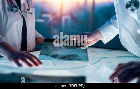 Two medical professionals interacting with touch screen in a futuristic setting, analyzing data and collaborating on innovative healthcare solutions Stock Photo