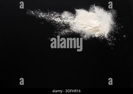 Sprinkled wheat flour splash spots on black background Stock Photo
