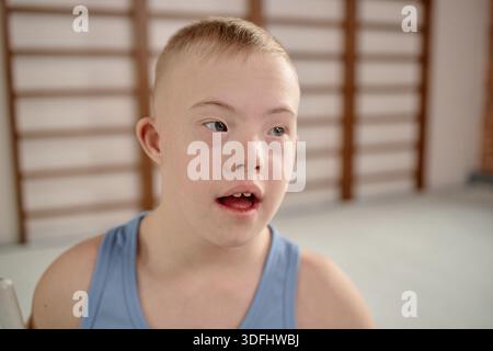 Portrait of Boy with Down Syndrome Smiling Indoors Facing Camera Stock Photo