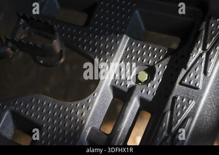 Close up black plastic floor mat with anti slip texture pattern and metal bolt showing sturdy industrial detail and safety design on vehicle footrest Stock Photo